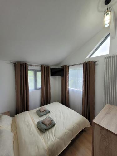 a bedroom with a bed with two towels on it at Cabana NEST in Bistricioara