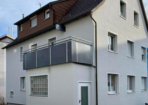 a white building with a balcony on top of it at Monteurwohnung in Oberkochen in Oberkochen