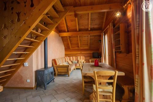 Un comedor con mesa y sillas y una escalera. en La Gelinotte - Jarrier, en Jarrier