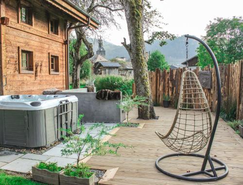 a garden with a hammock and a hot tub at La Ferme du Lac Vert in Montriond