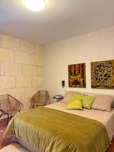 une chambre avec un grand lit et deux chaises dans l'établissement Maison De La Major, à Arles