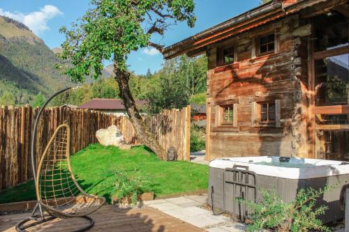 a hot tub in a yard next to a house at La Ferme du Lac Vert in Montriond
