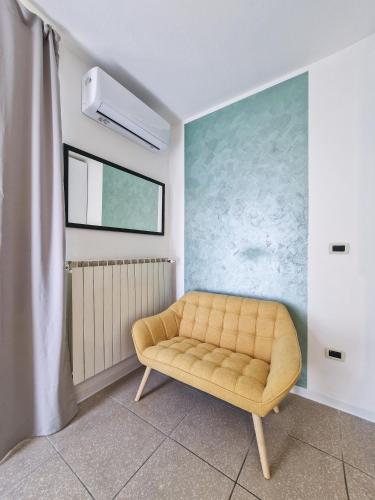 a yellow couch in a room with a blue wall at Casa Vacanze da Flora in Atessa