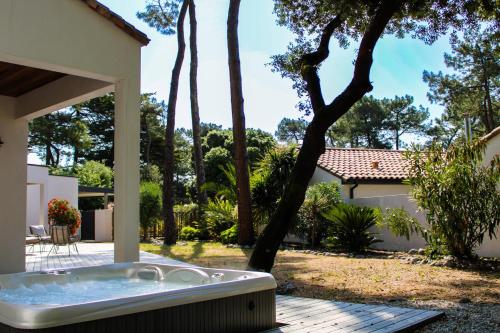 a jacuzzi tub sitting outside of a house at La Villa Pinède avec SPA à 5 minutes de la mer in Brétignolles-sur-Mer