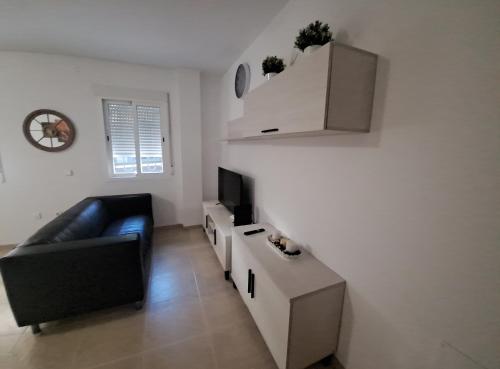 a living room with a couch and a television at Apartamento calle Senado in Garrucha