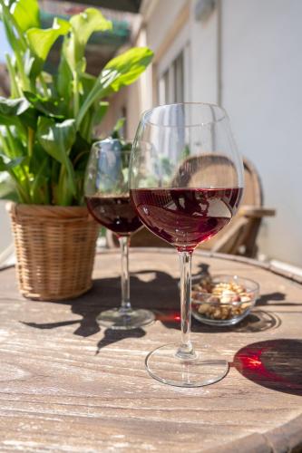 two glasses of red wine sitting on a table at Catania Over Time - Tourist Rooms in Catania