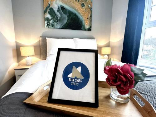 a bed with a framed picture on a wooden table at Newham House by Blue Skies Stays in Stockton-on-Tees