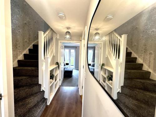 a hallway with stairs in a home with a mirror at Newham House by Blue Skies Stays in Stockton-on-Tees