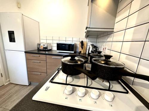 a kitchen with two pots and cups on a stove at Newham House by Blue Skies Stays in Stockton-on-Tees