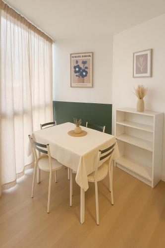 une salle à manger avec une table et des chaises blanches dans l'établissement Grand studio neuf, lumineux et au calme ! Tout équipé - Ajaccio, à Ajaccio