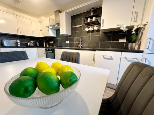 Un bol de fruta sobre una mesa blanca en una cocina. en Densham House by Blue Skies Stays, en Stockton-on-Tees