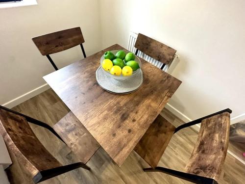 a wooden table with a bowl of fruit on it at Riverside View by Blue Skies Stays in Middlesbrough