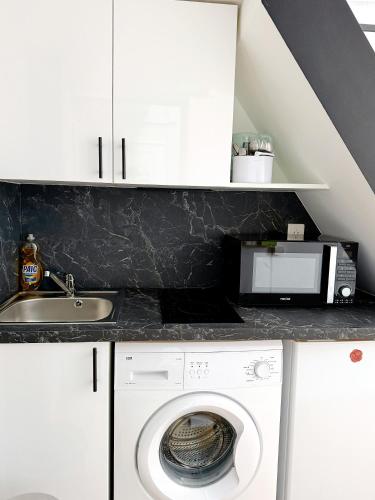 une cuisine avec un lave-linge et un micro-ondes dans l'établissement Stylish Loft Studio in Central Paris in Clery 4, à Paris