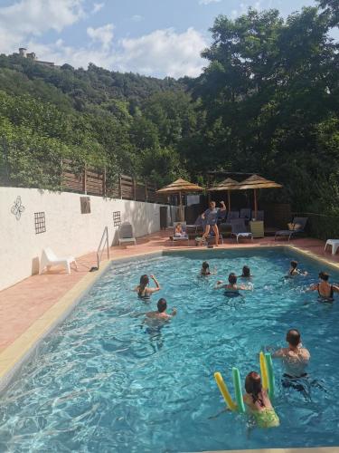 un groupe de personnes nageant dans une piscine dans l'établissement Camping Le Barutel, à Meyras