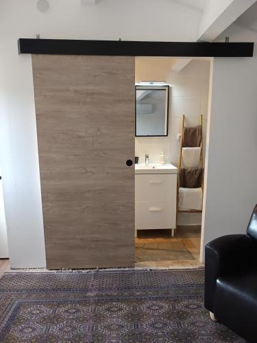 une porte coulissante menant à une salle de bains avec lavabo. dans l'établissement chambre independante, à Balaruc-les-Bains