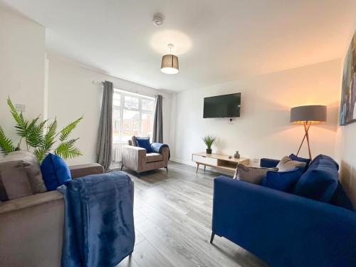 a living room with blue couches and a tv at Turnstile Place by Blue Skies Stays in Middlesbrough