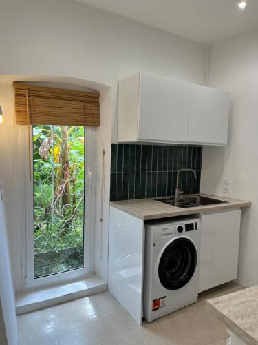 une cuisine avec une machine à laver et une fenêtre dans l'établissement Duplex au cœur de Vieille Ville Menton, à Menton