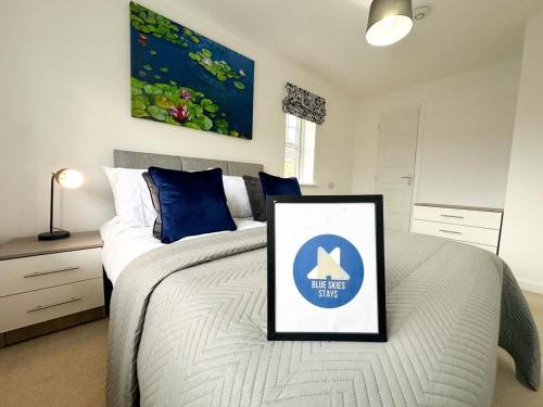 a bedroom with a bed with a framed picture on it at Bourneville House by Blue Skies Stays in Stockton-on-Tees