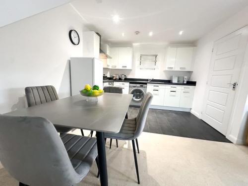 a kitchen with a table and chairs and a refrigerator at Bourneville House by Blue Skies Stays in Stockton-on-Tees