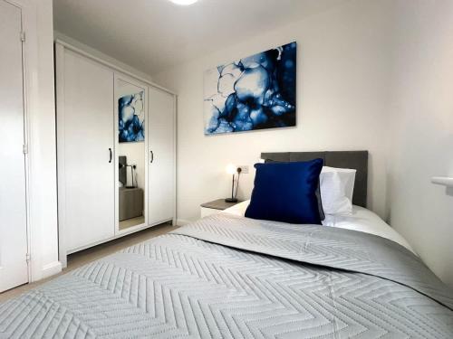 a bedroom with a bed with a blue pillow on it at Bourneville House by Blue Skies Stays in Stockton-on-Tees