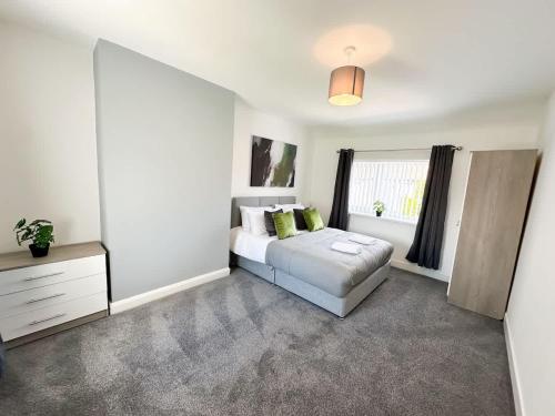 a white bedroom with a bed and a window at Malvern House by Blue Skies Stays in Stockton-on-Tees