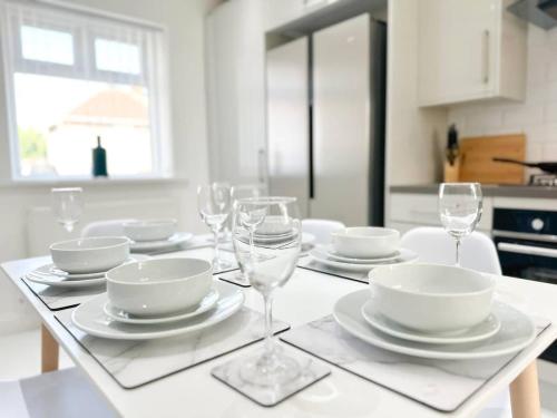 a table with plates and wine glasses on it at Malvern House by Blue Skies Stays in Stockton-on-Tees