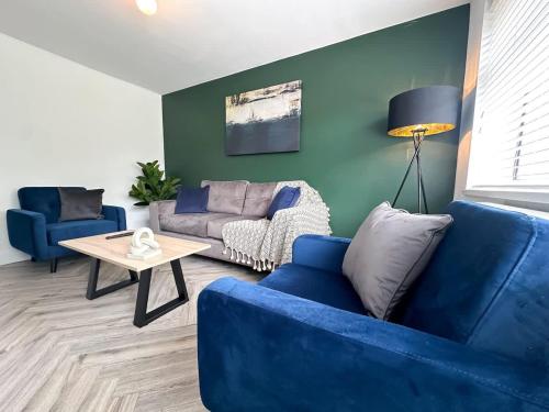 a living room with a blue couch and a table at Marham House by Blue Skies Stays in Middlesbrough