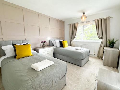 a bedroom with two beds and yellow pillows at Marham House by Blue Skies Stays in Middlesbrough