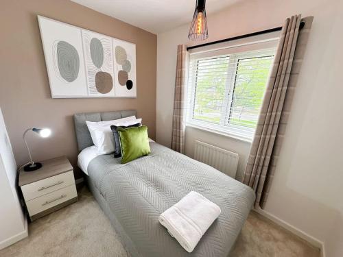 a small bedroom with a bed and a window at Marham House by Blue Skies Stays in Middlesbrough
