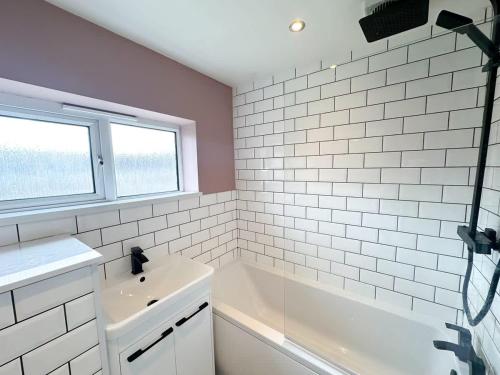a white bathroom with a tub and a window at Marham House by Blue Skies Stays in Middlesbrough