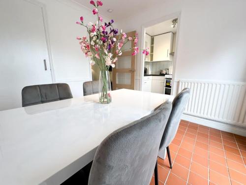 a vase of flowers sitting on a table with chairs at Anchorage Place by Blue Skies Stays in Thornaby on Tees