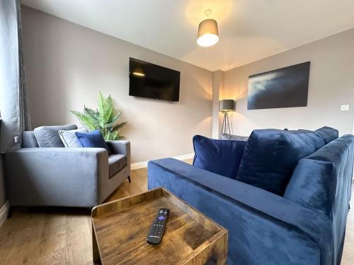 a living room with a blue couch and a table at Geranium House by Blue Skies Stays in Stockton-on-Tees