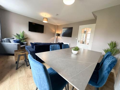 a living room with a table and blue chairs at Geranium House by Blue Skies Stays in Stockton-on-Tees