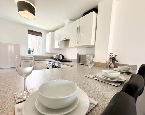 a kitchen with a table with plates and wine glasses at Chestnut House by Blue Skies Stays in Middlesbrough