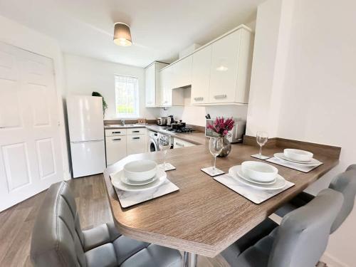 a kitchen with a wooden table with chairs around it at Deepdale House by Blue Skies Stays in Stockton-on-Tees