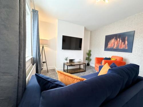a living room with a blue couch and a tv at Turton House by Blue Skies Stays in Stockton-on-Tees