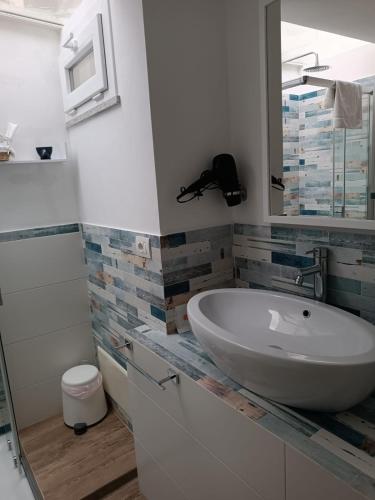 a bathroom with a sink and a mirror at Oltremare in Cefalù