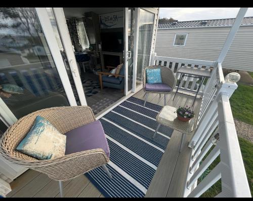 a porch with two chairs and a table and a table at The Lighthouse Caravan in Wyke Regis