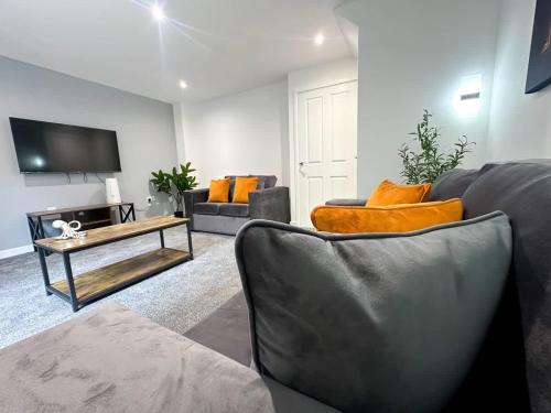 a living room with two couches and a tv at Essex House by Blue Skies Stays in Stockton-on-Tees