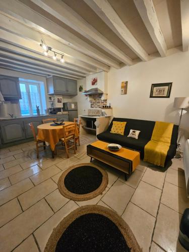 a living room with a couch and a table at Butterfly Cottage in Pouilly-sur-Loire