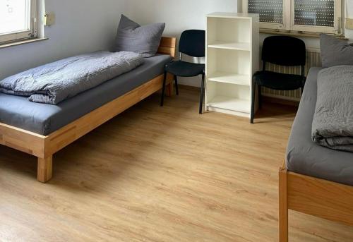 a bedroom with a bed and a wooden floor at Monteurwohnung in Oberkochen in Oberkochen