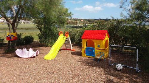 un parque infantil con un tobogán y un juego de juegos en B&B Bella Calasetta, en Calasetta