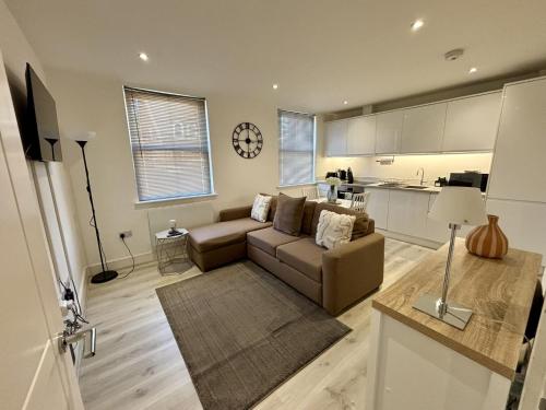 a living room with a couch and a kitchen at Gogmore Lane in Chertsey