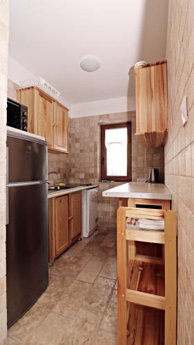 a kitchen with wooden cabinets and a stainless steel refrigerator at Domki Na Wzgórzu in Nowica