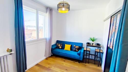 a blue couch in a room with a window at Levalet BNB - La Défense Courbevoie in Courbevoie