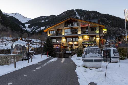 a hotel with a boat parked in the snow at Apartaments Sant Moritz in Arinsal