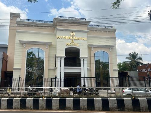 a large white building with people in front of it at Hyders Mahal & Hotel in Thanjāvūr