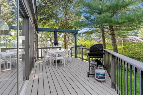 a grill on a porch with a table and chairs at Villa de Lago in Champlin