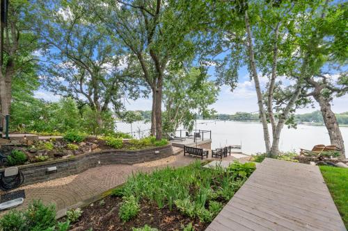 a wooden walkway next to a lake with trees at Villa de Lago in Champlin