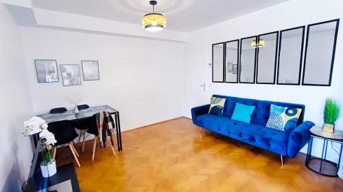 un salon avec un canapé bleu et une table dans l'établissement Levalet BNB - La Défense, à Courbevoie
